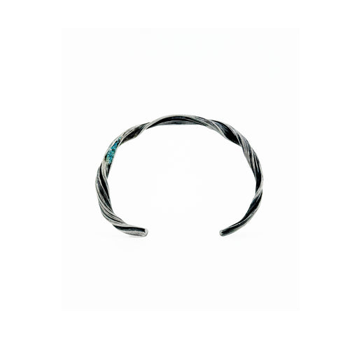 a sterling silver twisting sculptural cuff bracelet that  is inlaid with turquoise to resemble the blue sky peaking thru openings in the red rock slot canyons of Antelope Canyon by jewelry artist michelle hoting