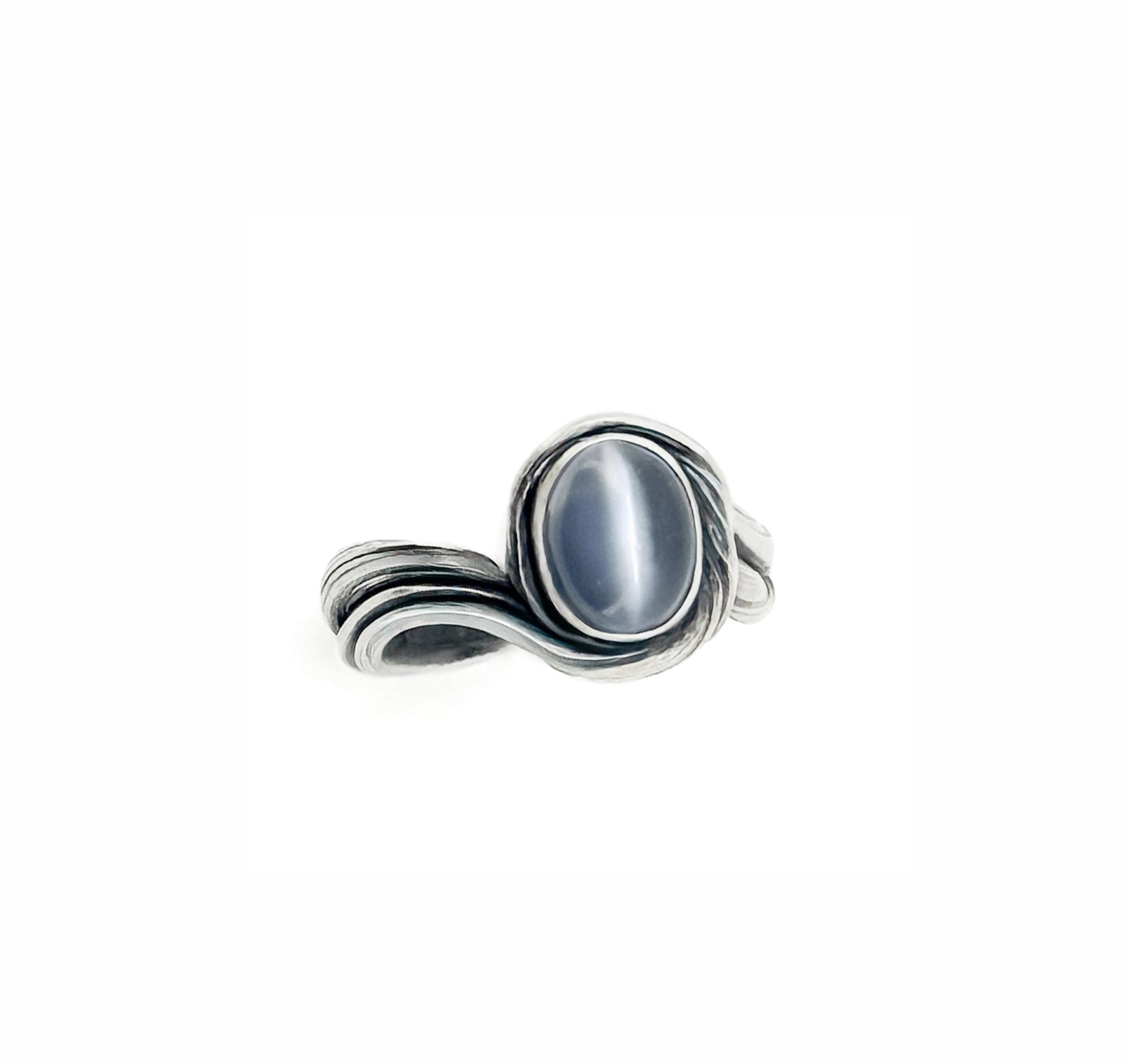 a ring in flowing silver that resembles an ocean cove set with an oval cat's eye moonstone cabochon by Michelle Hoting created using mitsuro hikime