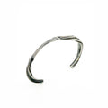 a sterling silver cuff bracelet made to resemble waves washing onto a rocky shoreline by sculptural jeweler michelle hoting using mitsuro hikime