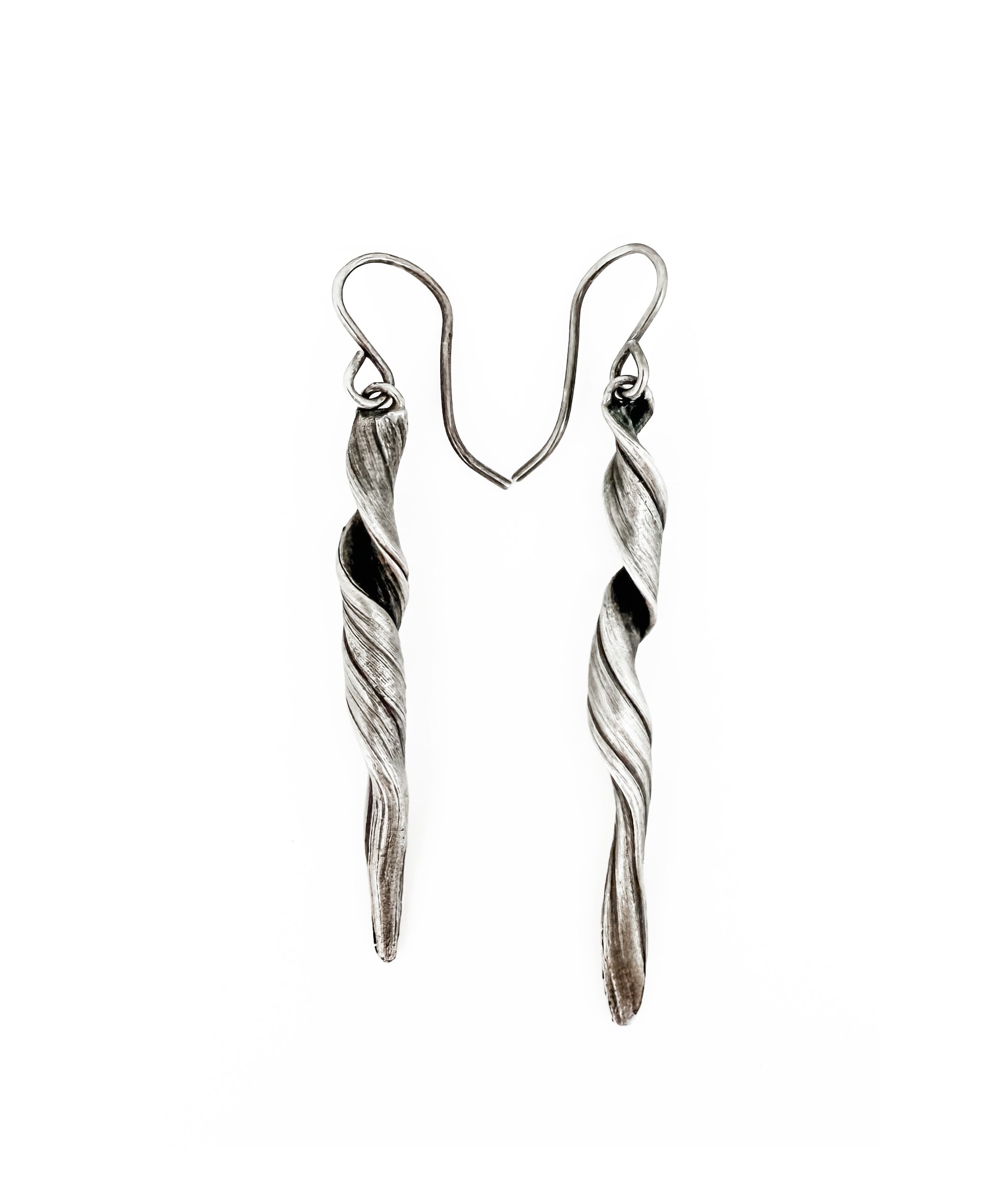 a pair of sterling silver earrings with a sculptural wave like twisting pattern hand fabricated by jewelry artist Michelle Hoting using the Mitsuro Hikime technique
