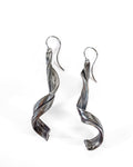 a pair of silver earrings with a graceful gentle swirl made by contemporary craft jeweler michelle hoting using the mitsuro hikime art form