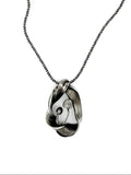 silver pendant with mushrooms surrounded by a undulating frame
