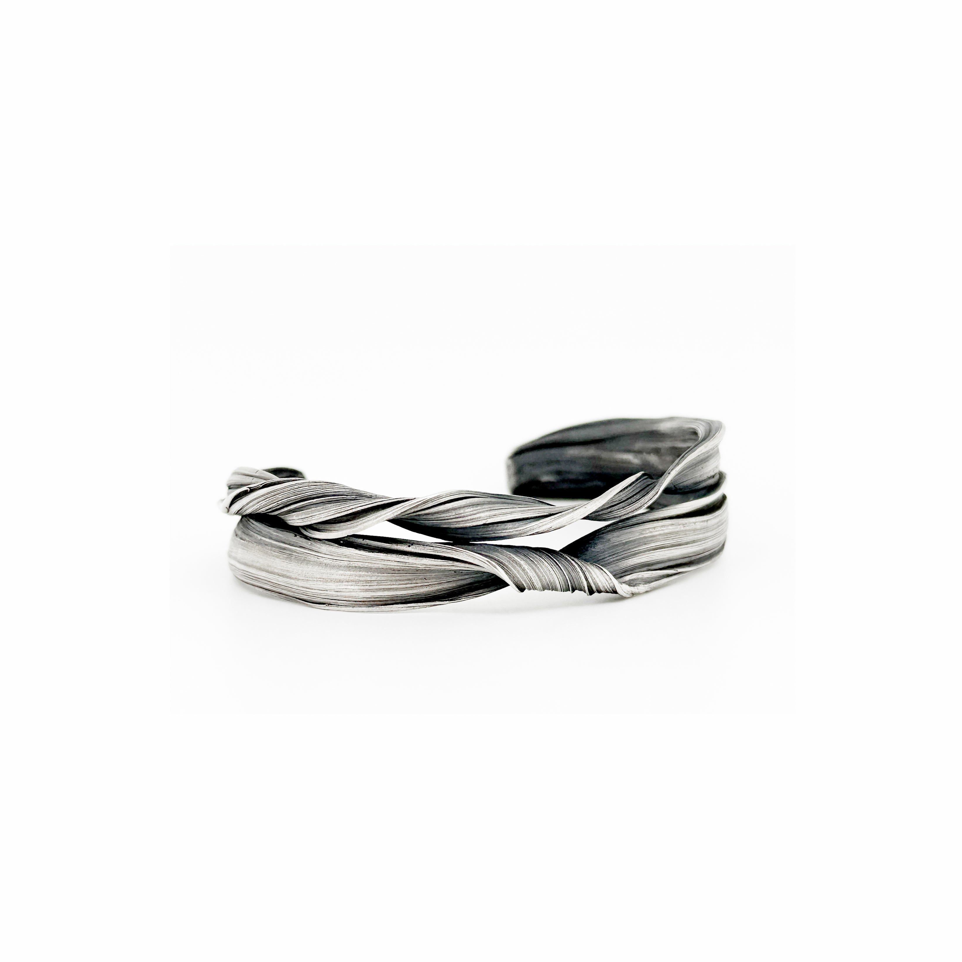a sterling silver cuff bracelet created to resemble undulating curling waves by jewelry artist Michelle Hoting using the Mitsuro Hikime technique
